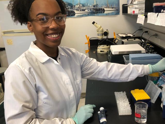 smiling student at lab bench